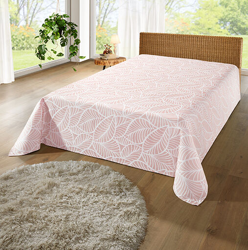 Bett mit rosa gemusterten Tagesdecke