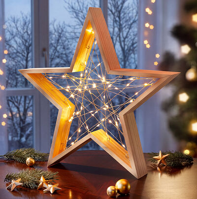 Leuchtender Holzstern mit Lichterkette am Fenster