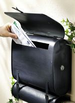 Briefkasten Schultasche mit Zeitungsrolle