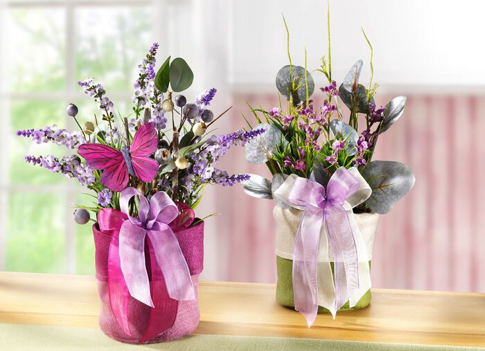 Fr&uuml;hlingsgesteck mit Blumen und Gr&auml;ser im Filzbeutel LILA